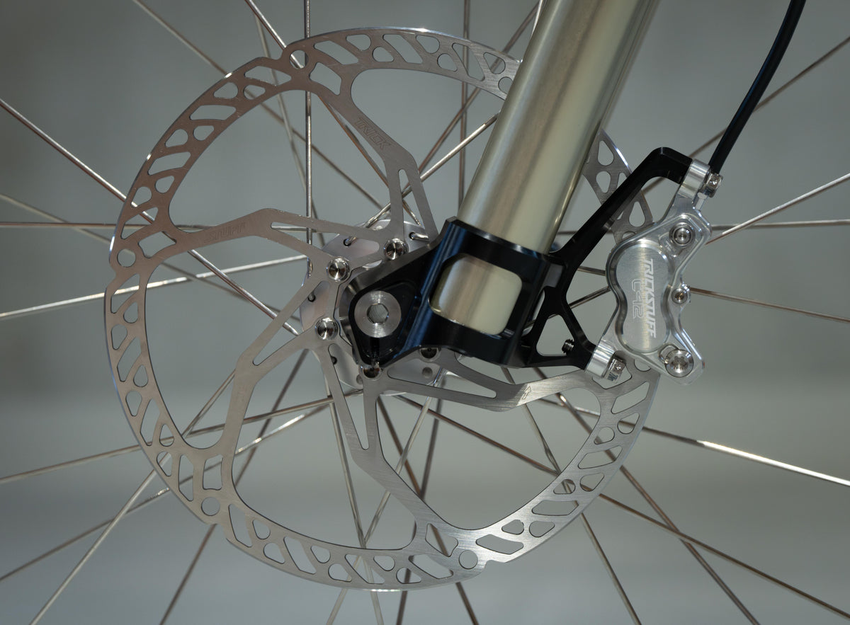 Trickstuff Dächle Ultralight rotor installed in a front wheel beside a silver caliper and fork.